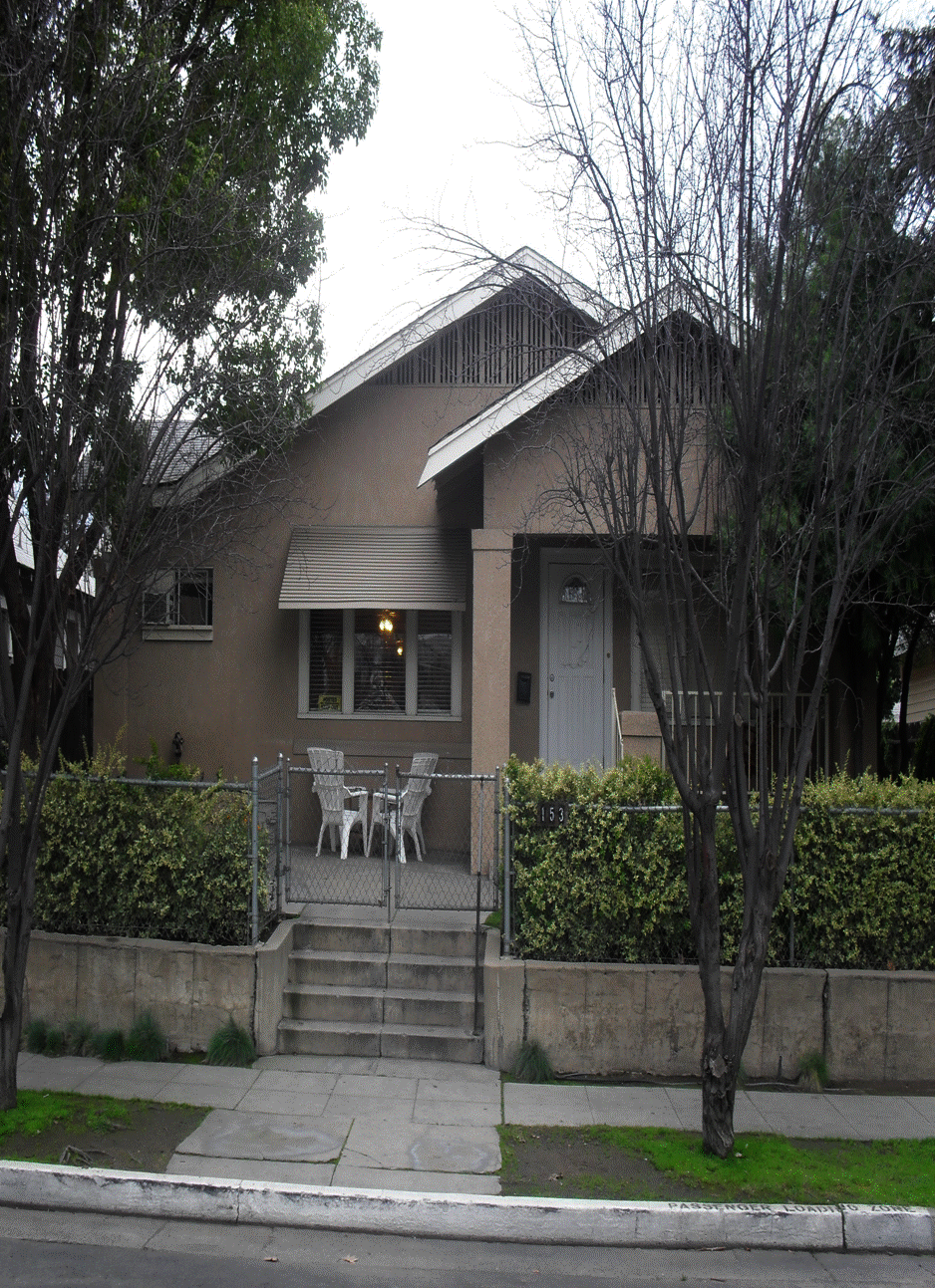 Curb Side view of Fresno Bridge house with chairs on patio